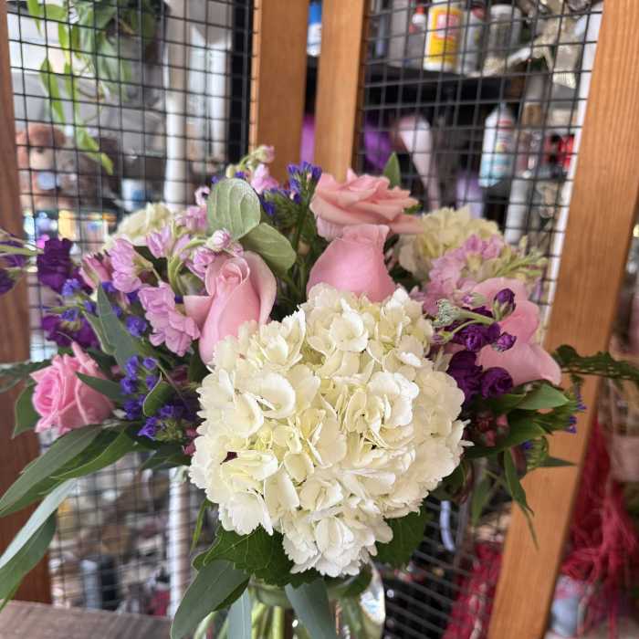 Pink roses and white hydrangeas arranged in a glass vase