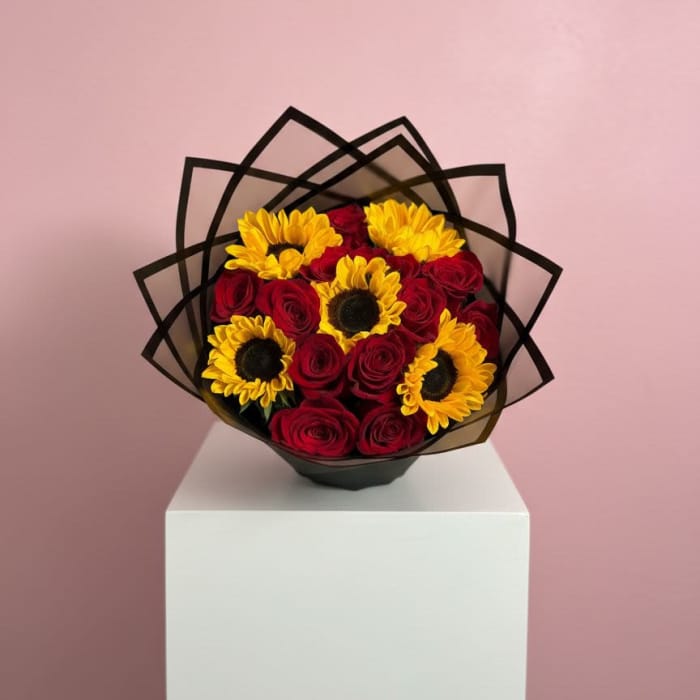 Bouquet of red roses and yellow sunflowers wrapped in black paper