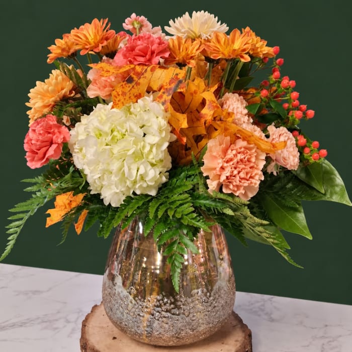 Autumn bouquet of mums, carnations, and hydrangea in a metallic vase