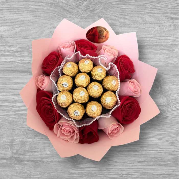 Pink and red roses arranged around gold-wrapped chocolates