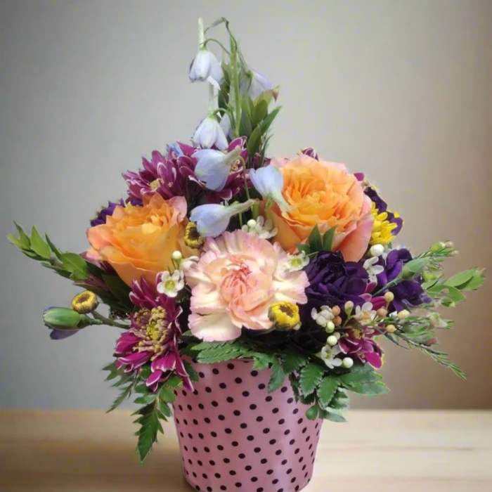 Colorful mixed bouquet in a pink polka-dot pot