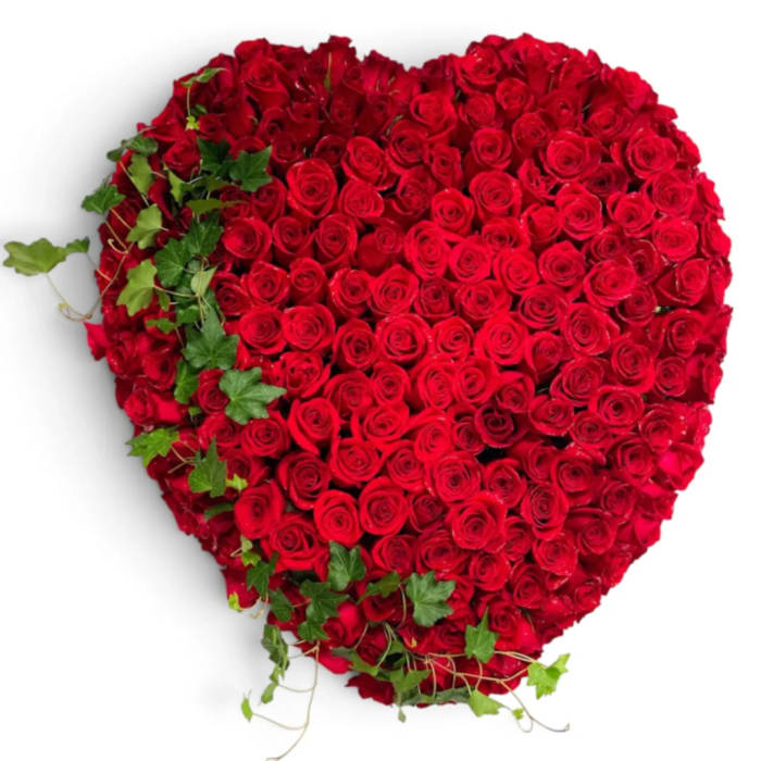 Heart-shaped arrangement of red roses with ivy accents