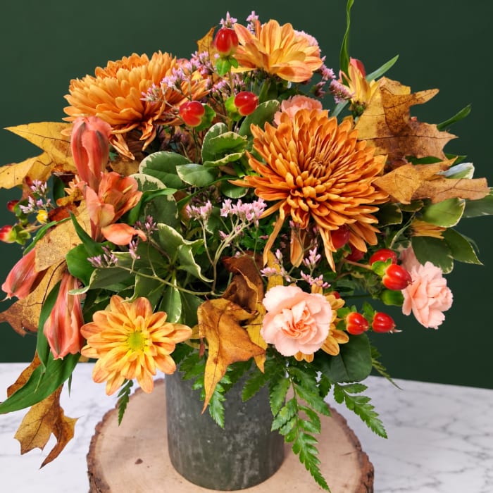 Autumn bouquet with orange chrysanthemums and pink carnations in a metal vase