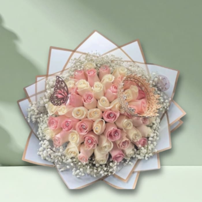 Bouquet of pink and cream roses with baby’s breath and decorative butterfly accents