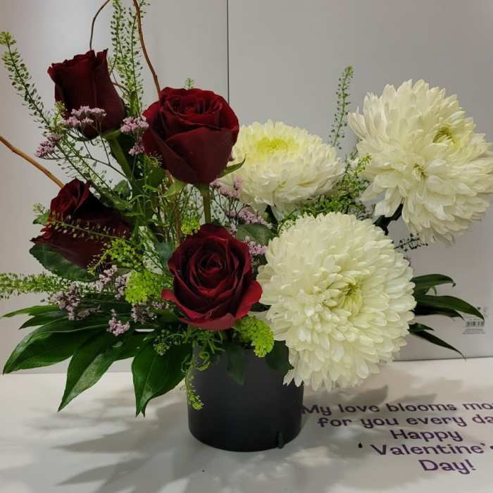 Red roses and white chrysanthemums in a black vase