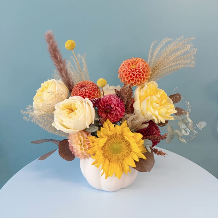 Mixed bouquet in a white vase with sunflowers, roses, and dahlias