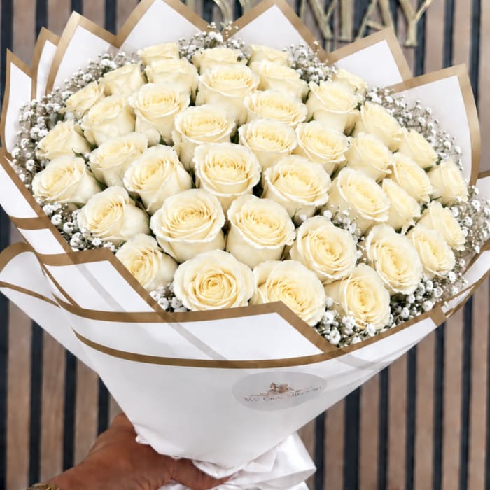 Bouquet of cream roses wrapped in white and gold paper