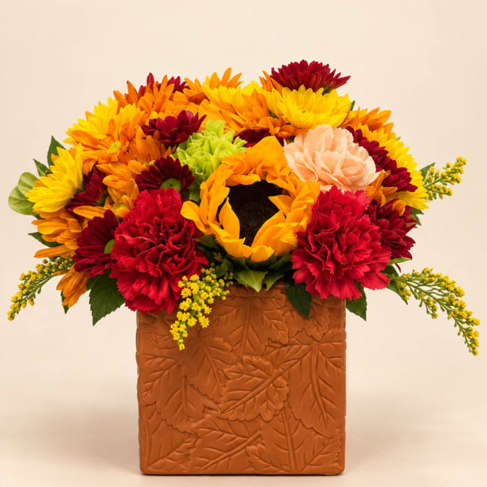 Colorful bouquet of sunflowers and carnations in a textured brown vase