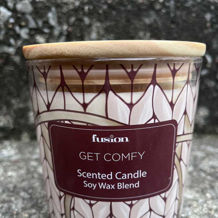 Scented candle in a patterned glass jar with a wooden lid