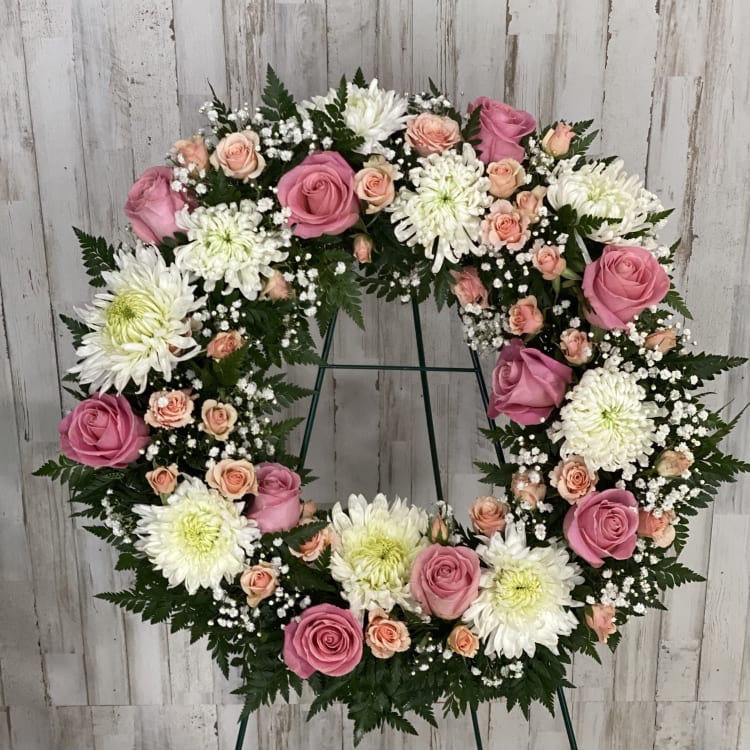 Pink and white floral wreath on a stand