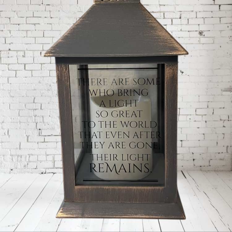 Wooden lantern with a memorial quote on the glass front