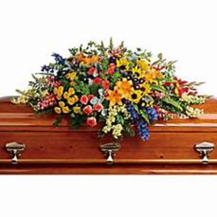 Colorful floral spray on a wooden casket