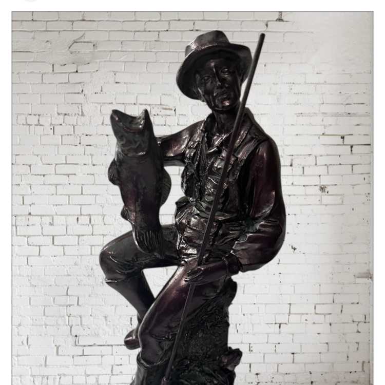 Bronze statue of a seated man holding a fish and a fishing pole