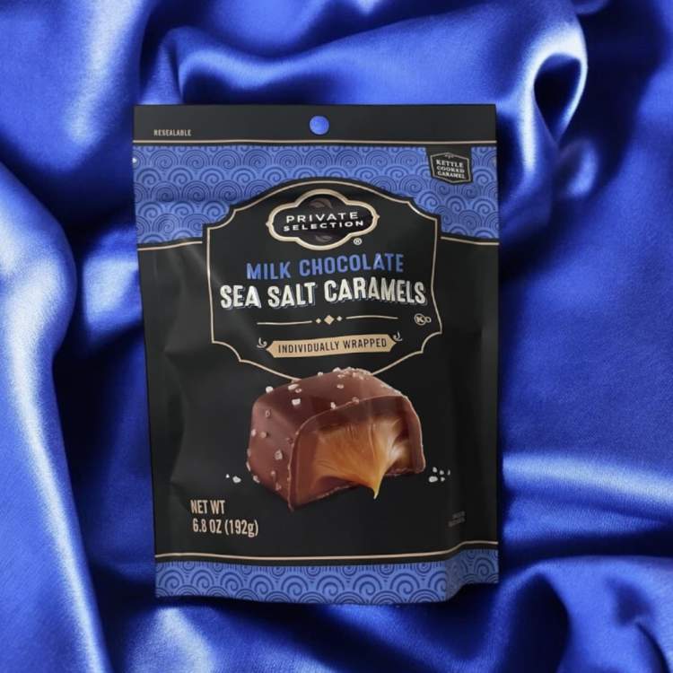 Bag of milk chocolate sea salt caramels on blue satin fabric