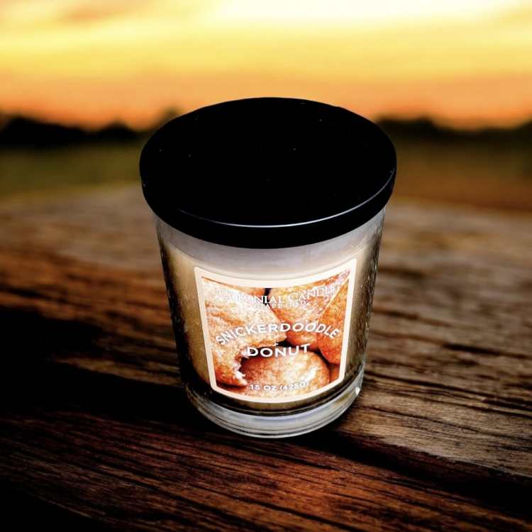 A scented candle in a glass jar with a black lid