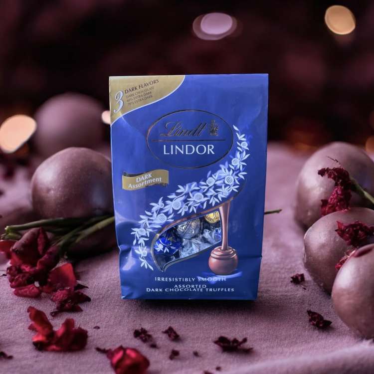 Box of Lindt Lindor dark chocolate truffles surrounded by wrapped chocolates