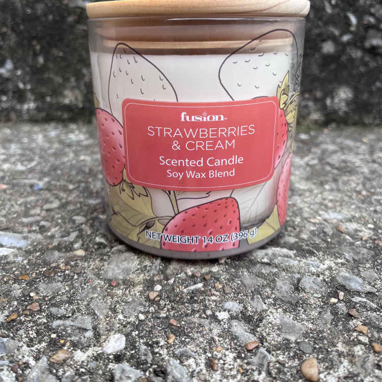 Strawberries and cream scented candle in a glass jar with a wooden lid