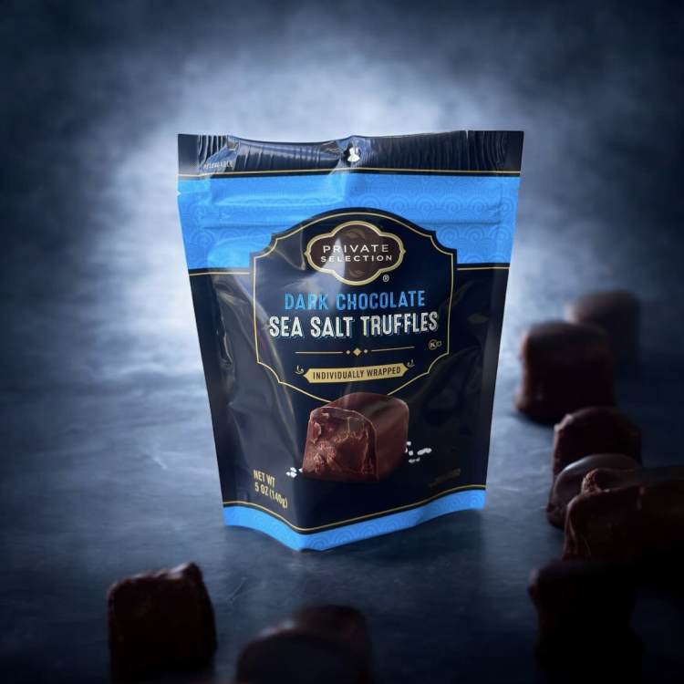 Bag of dark chocolate sea salt truffles with pieces scattered around