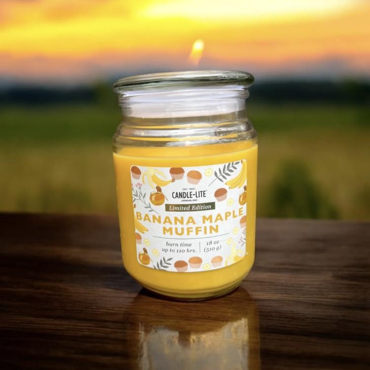 Yellow candle in a glass jar with a banana maple muffin label
