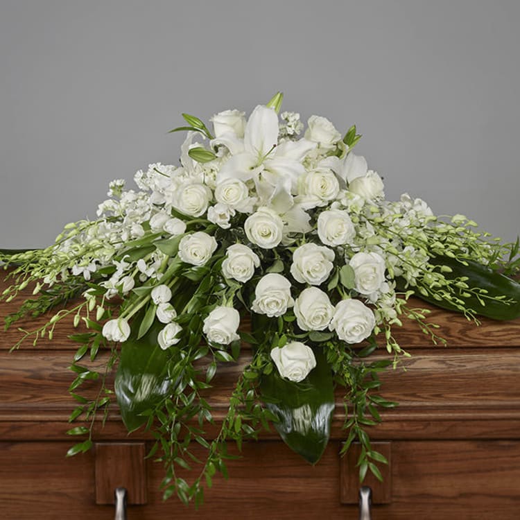 White floral casket spray with roses and lilies