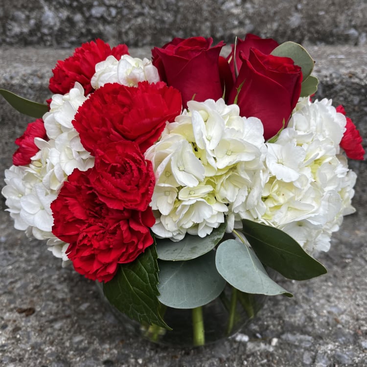 Red roses and white carnations in a glass vase