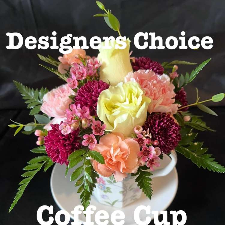 Small floral arrangement in a floral coffee cup and saucer