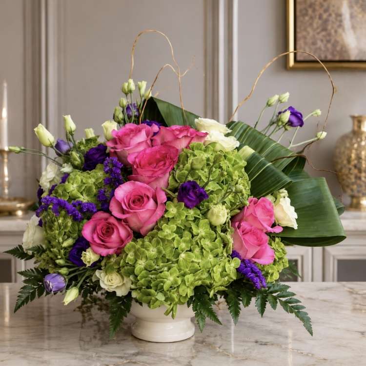 Pink roses and green hydrangeas in a white vase with purple accents