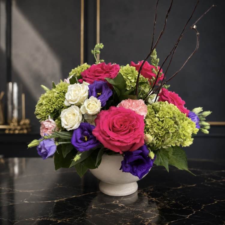Colorful flower arrangement in a white pedestal bowl