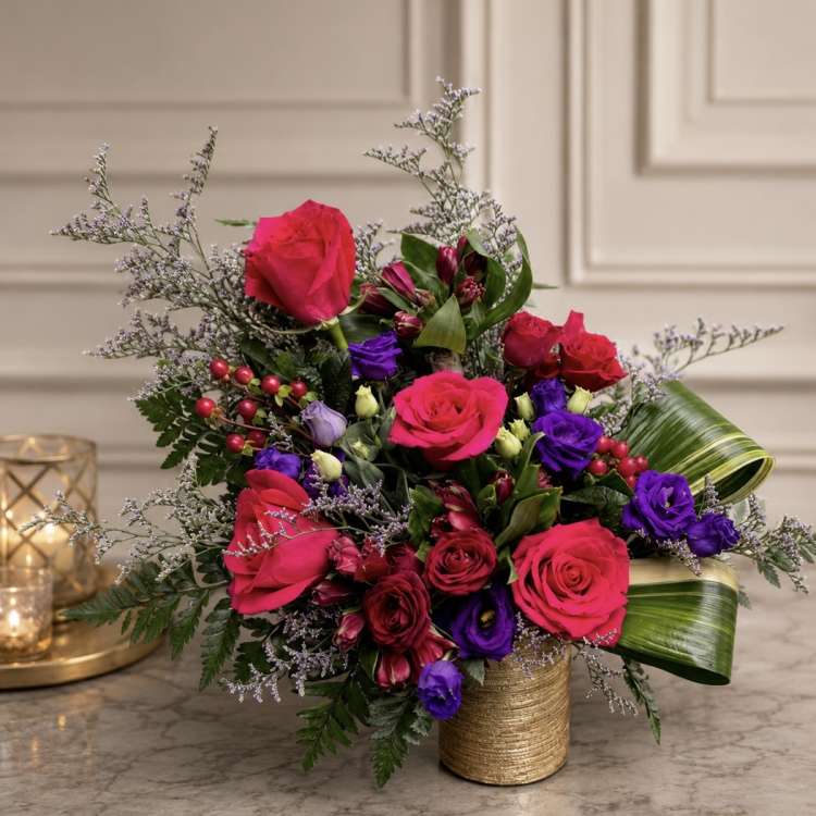 Bouquet of hot pink and purple roses in a gold vase