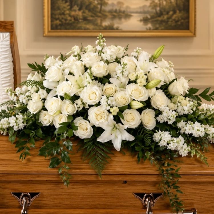 White rose and lily casket spray with greenery