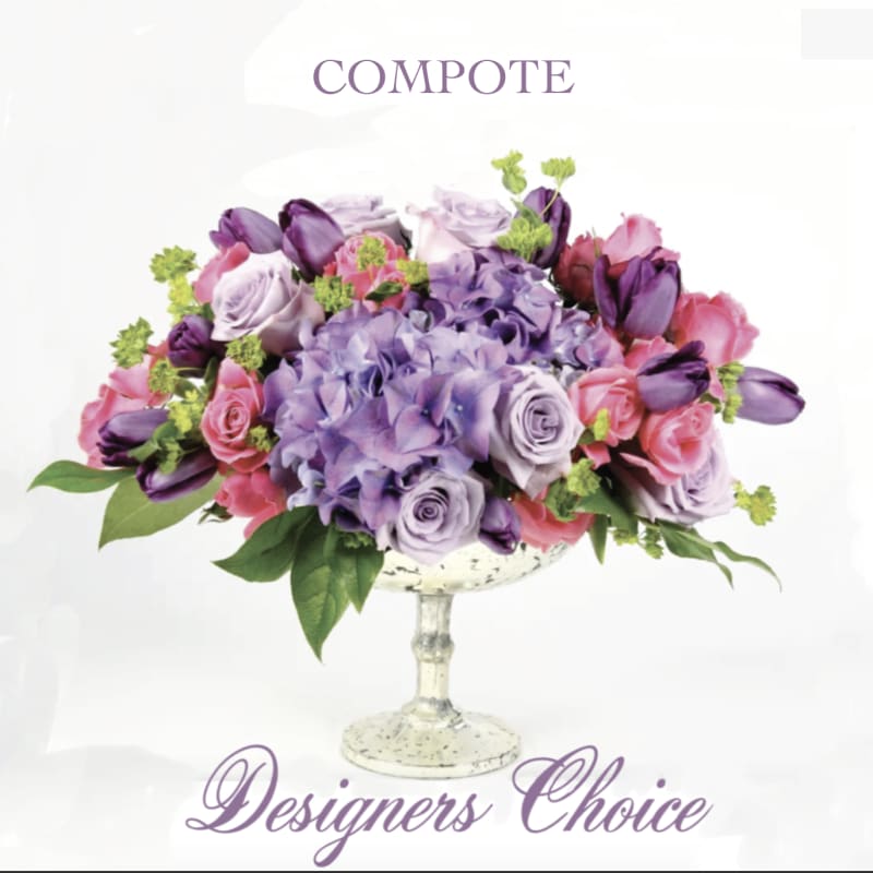 Purple and pink floral arrangement in a pedestal compote vase