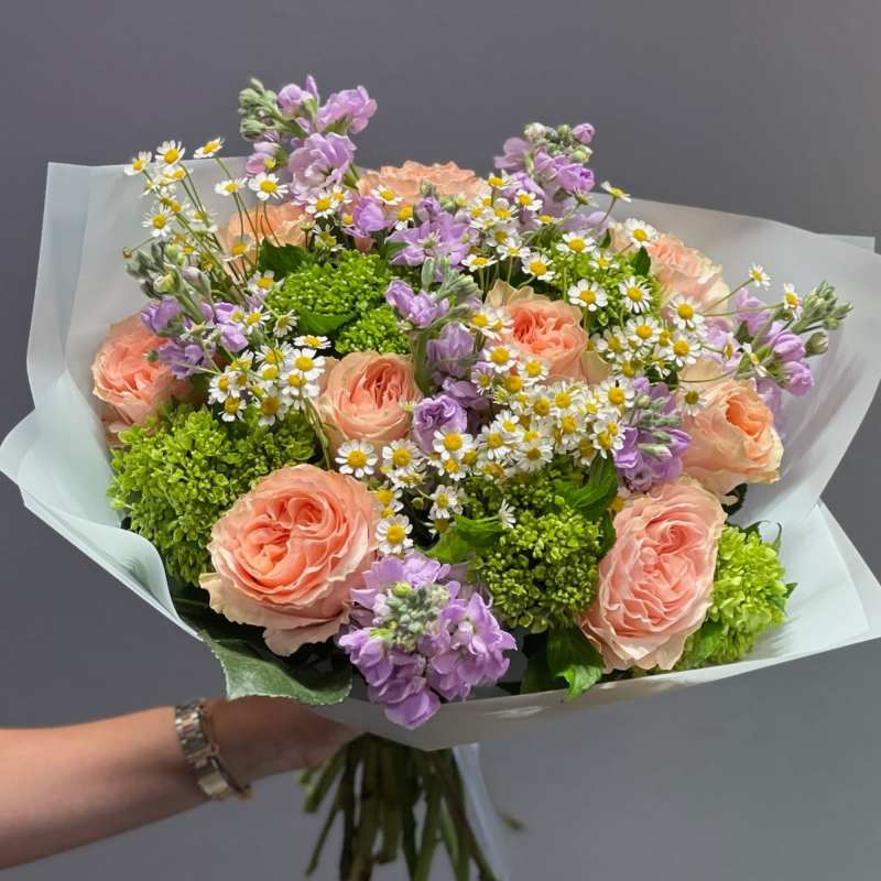 Bouquet of peach roses, purple flowers, and white daisies
