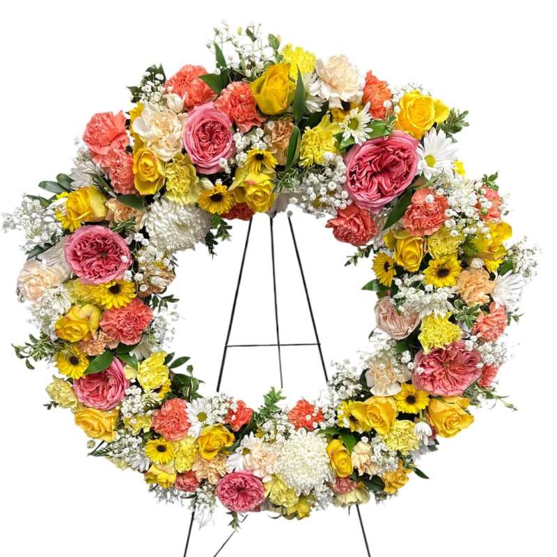 Large circular wreath of mixed flowers on a black easel