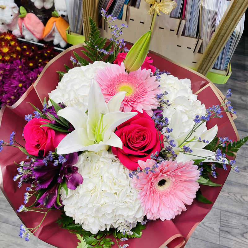 Bouquet of pink roses, white lilies, and pink gerbera daisies