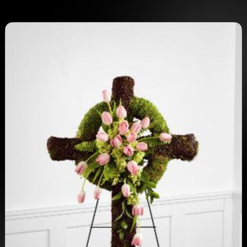 Floral cross with pink tulips and greenery on an easel