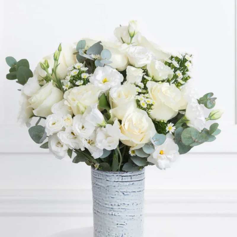 White rose bouquet in a textured silver vase