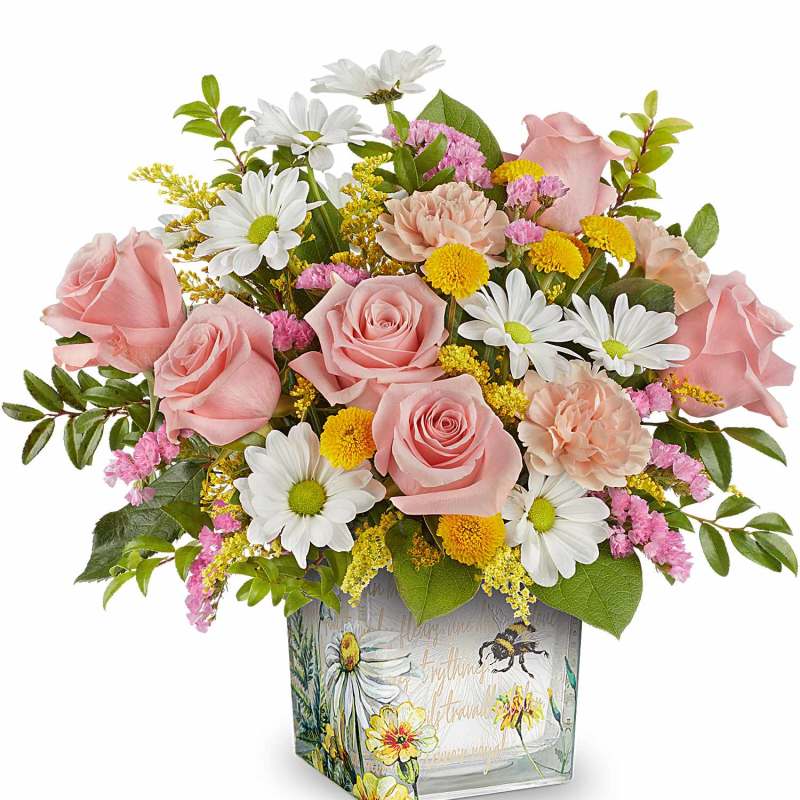 Pink roses and daisies arranged in a square glass vase