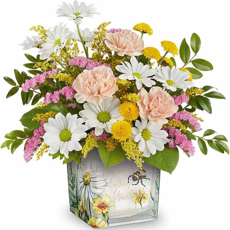Mixed bouquet of daisies, carnations, and yellow filler flowers in a decorated glass vase