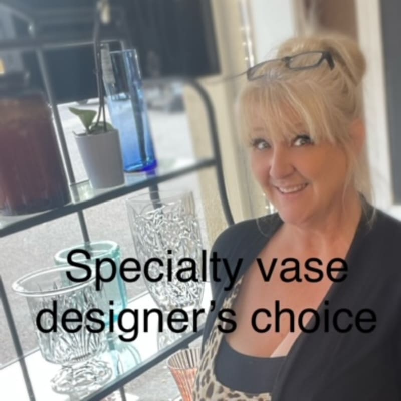 Woman standing by decorative glass vases on a shelf