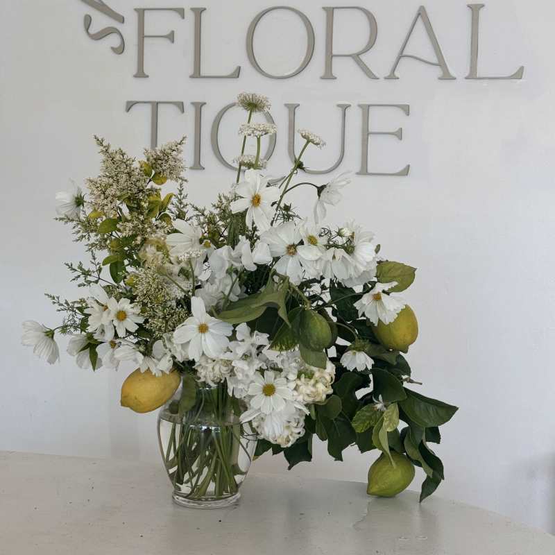 White daisy bouquet with lemons in a clear glass vase