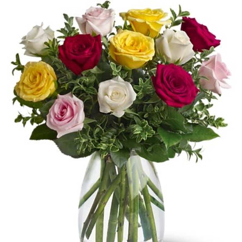 Mixed roses in pink, red, yellow, and white in a clear glass vase
