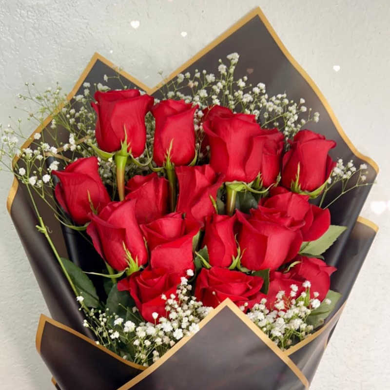 Bouquet of red roses with baby's breath in black wrap and a red ribbon