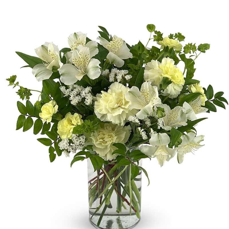 White and pale yellow flowers in a clear glass vase