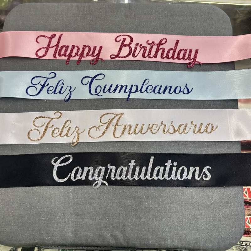 Four glittered satin ribbons with birthday and congratulations messages