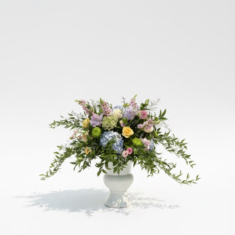 Mixed pastel bouquet in a white pedestal vase
