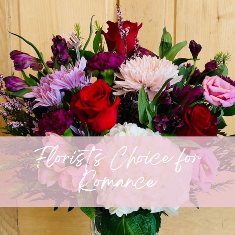 Mixed bouquet of red, pink, and purple flowers in a vase