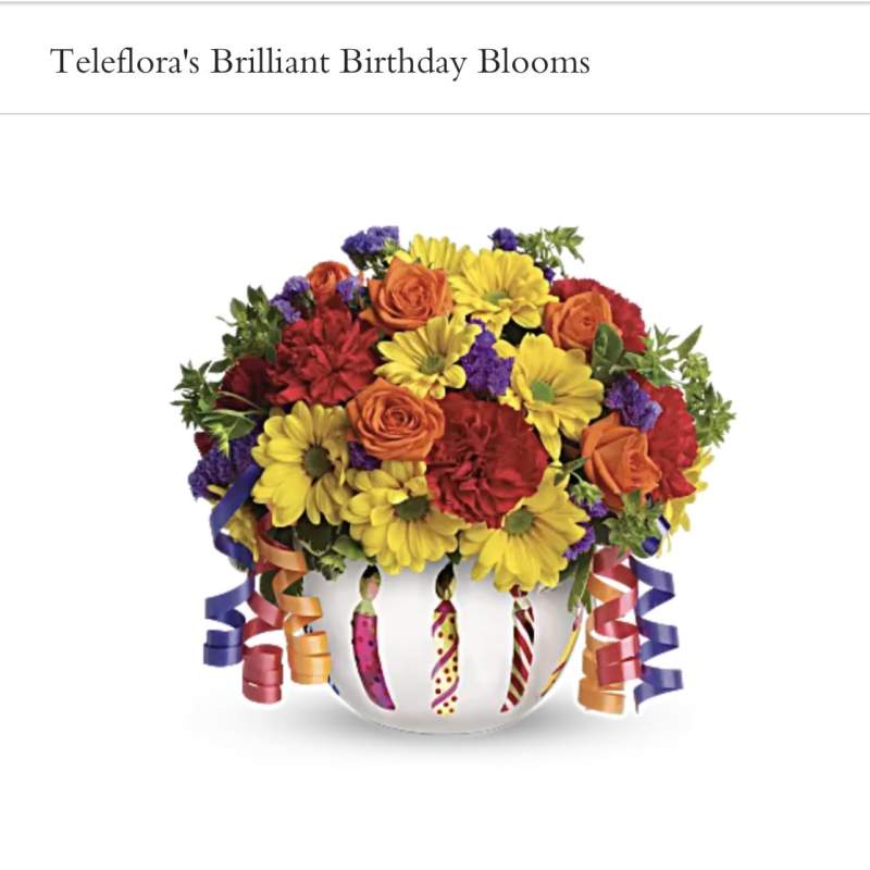 Colorful bouquet in a white vase with curled ribbon decorations