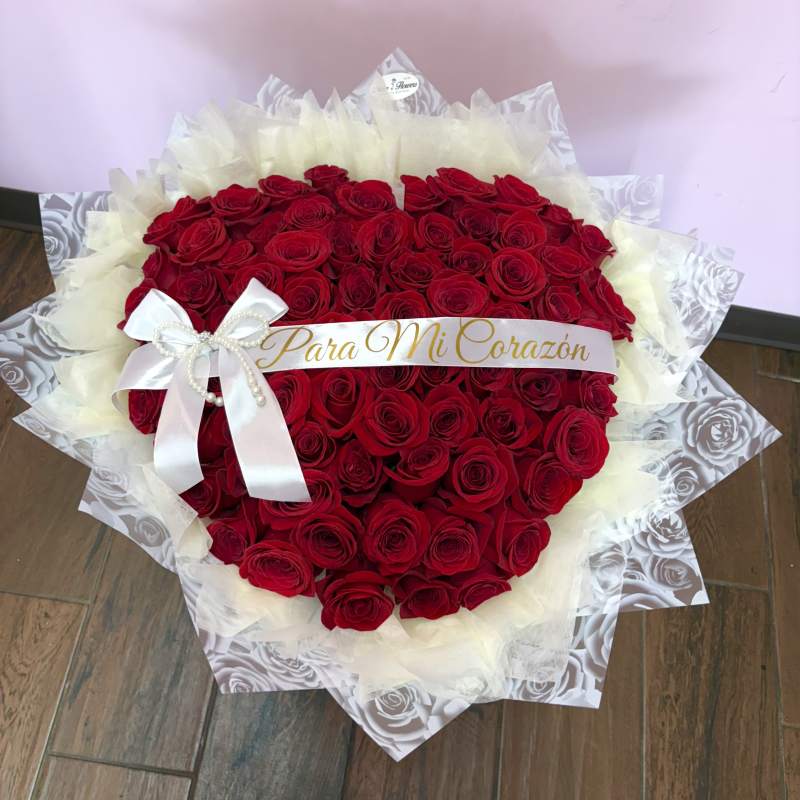 Large bouquet of red roses wrapped in white paper with a ribbon