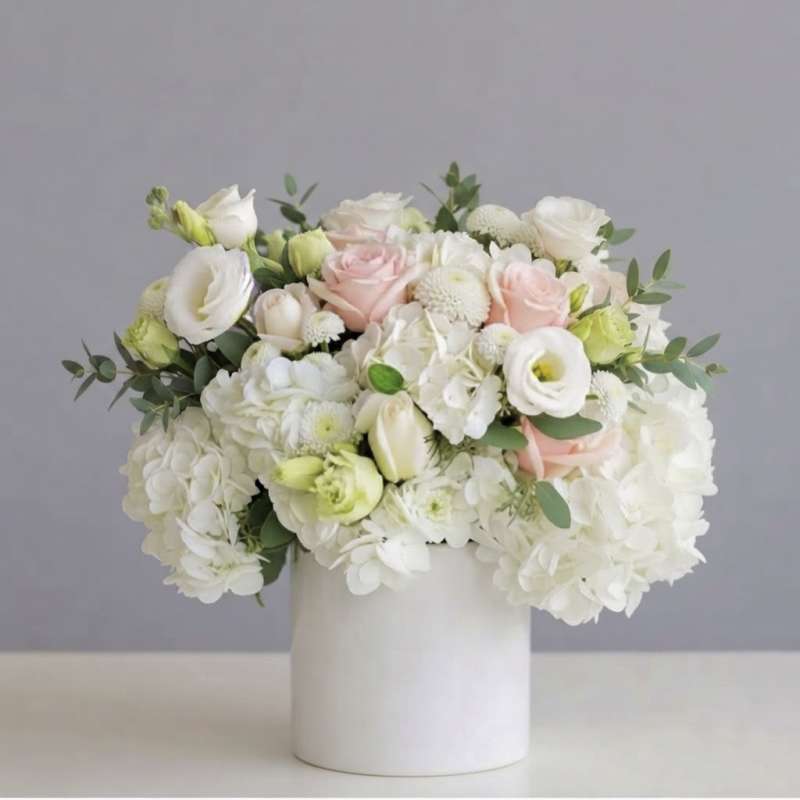 White and blush bouquet in a white cylindrical vase