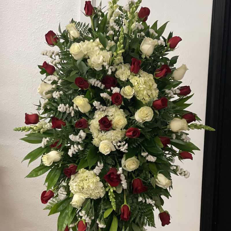 Tall standing floral spray with red and white roses and cream hydrangeas